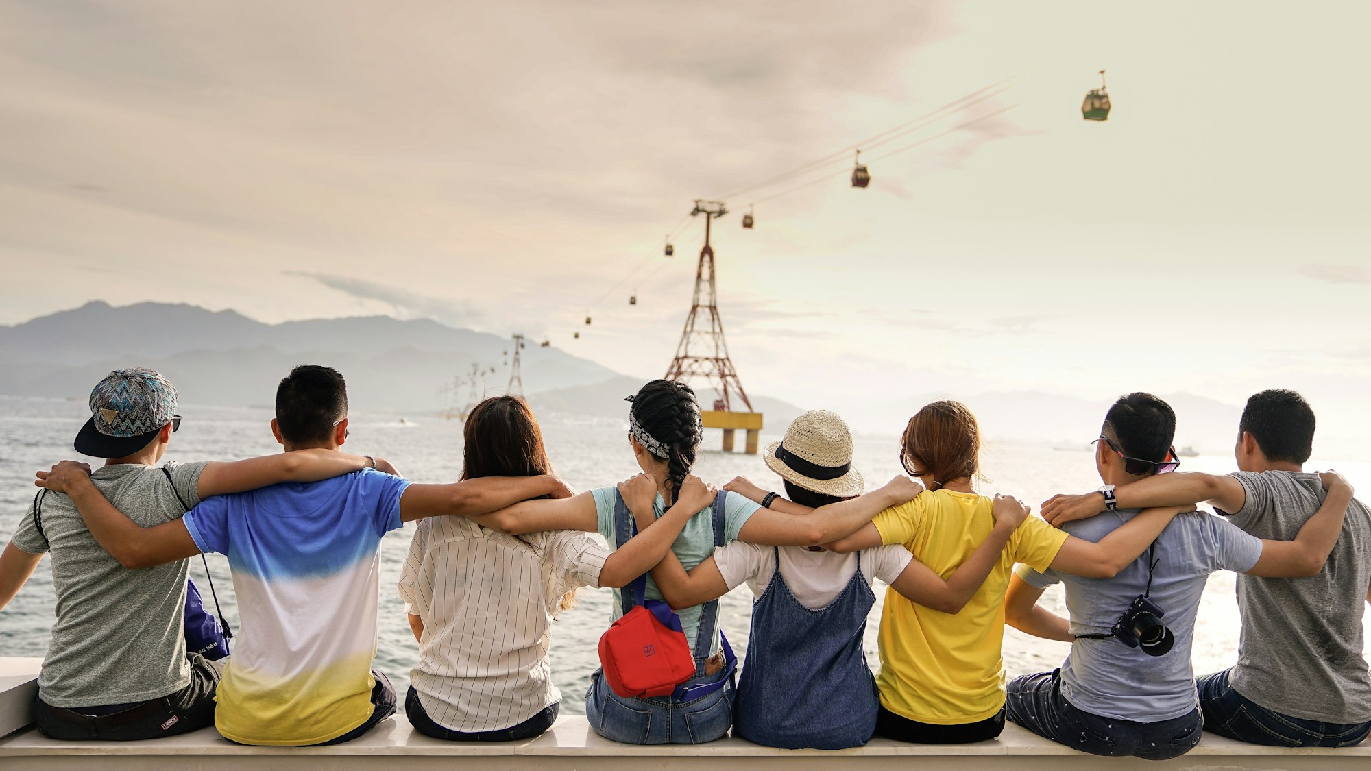 Friends sitting arm in arm looking at the horizon